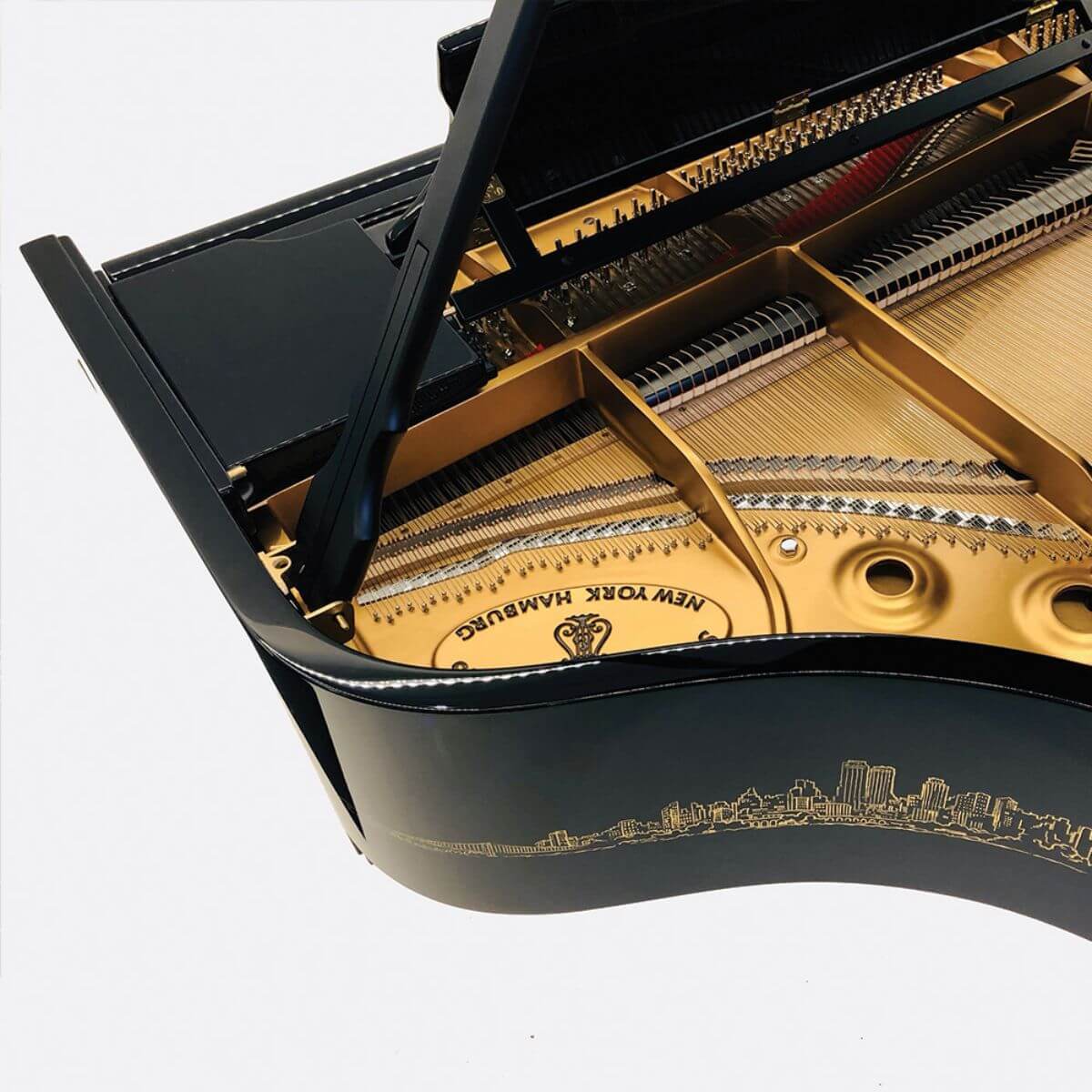 closeup of piano strings, also showing the skyline design on the outside of piano