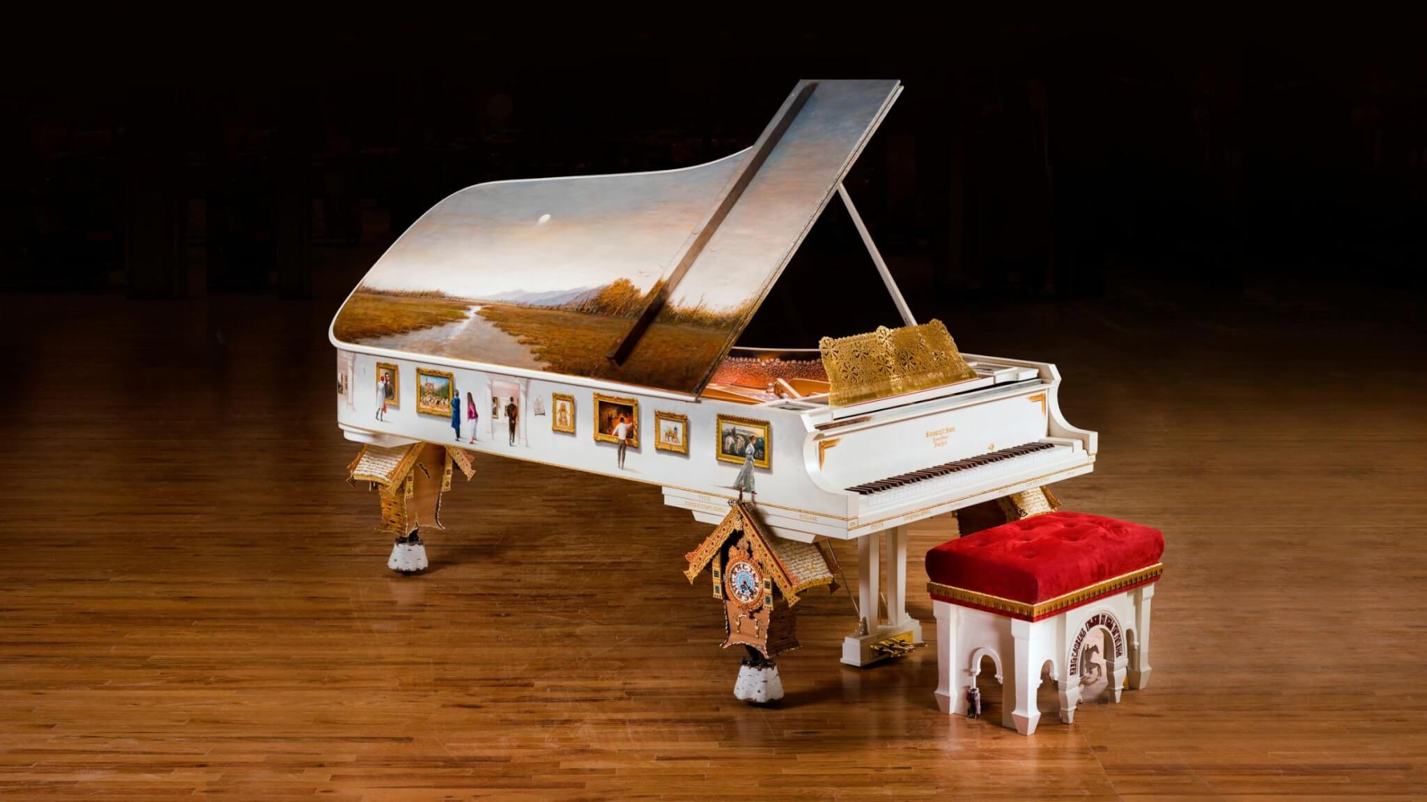 full view of Steinway piano showing the birdhouse shaped legs and the painting on the top and side of the piano